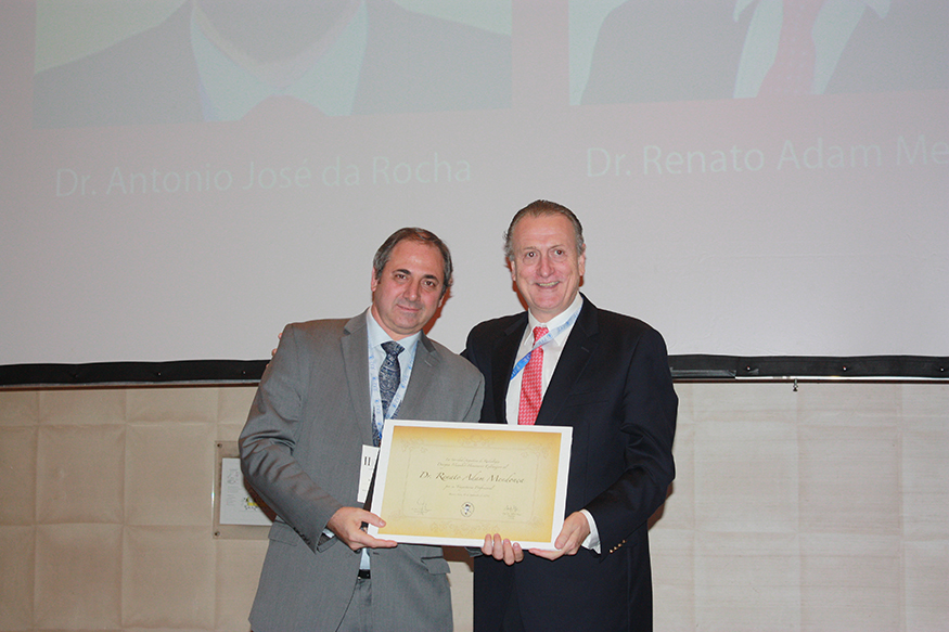 Dr. Alfredo Buzzi entregando distinción al Dr. Renato Mendonca