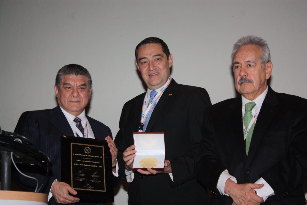 Dr. José Arturo Castilla Lima recibiendo premio a la Excelencia Académica por el Dr. Carlos Rodriguez T. y el Dr. José Luis Ramírez Arias