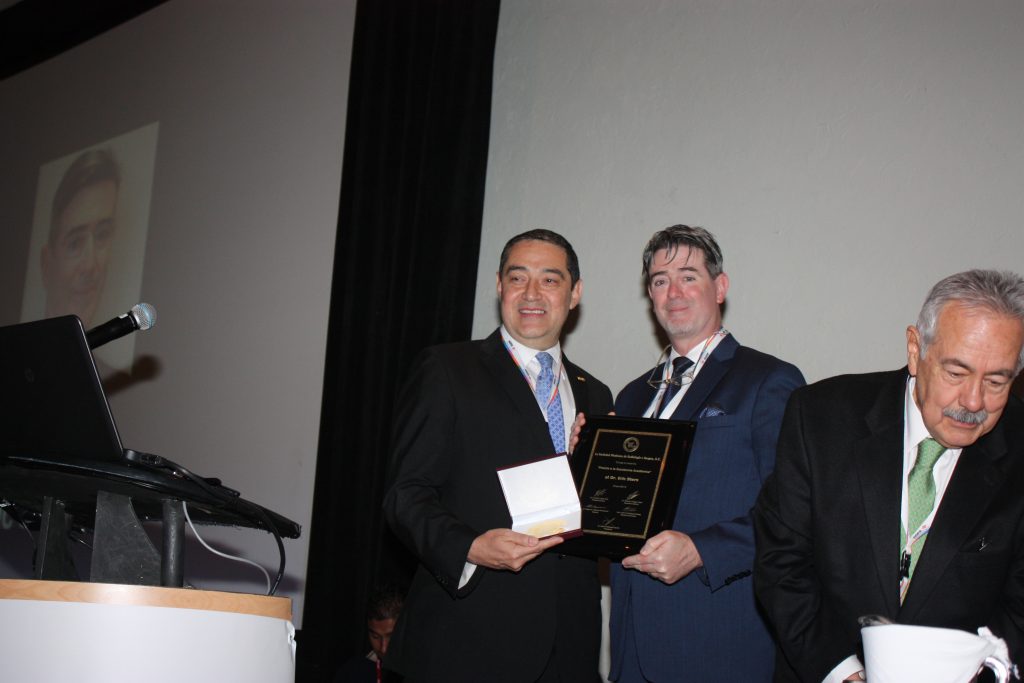 Dr. Eric Stern recibiendo premio a la Excelencia Académica por el Dr. Carlos Rodriguez T. y el Dr. José Luis Ramírez Arias